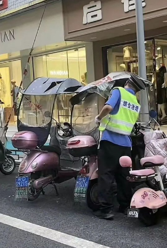 重庆一执法人员挨个划破电动车防雨棚